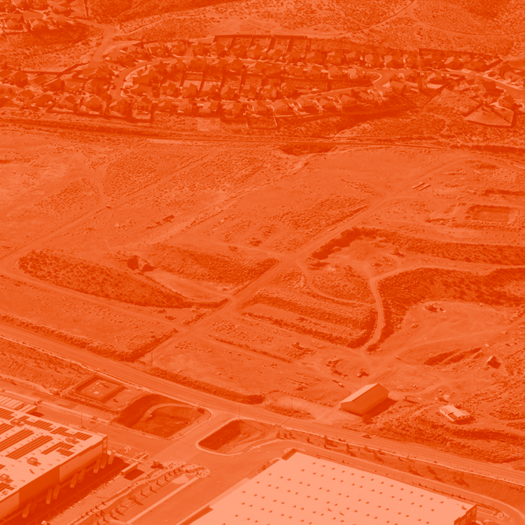 Aerial view of land prior to being developed. The image is edited with an orange duotone look.