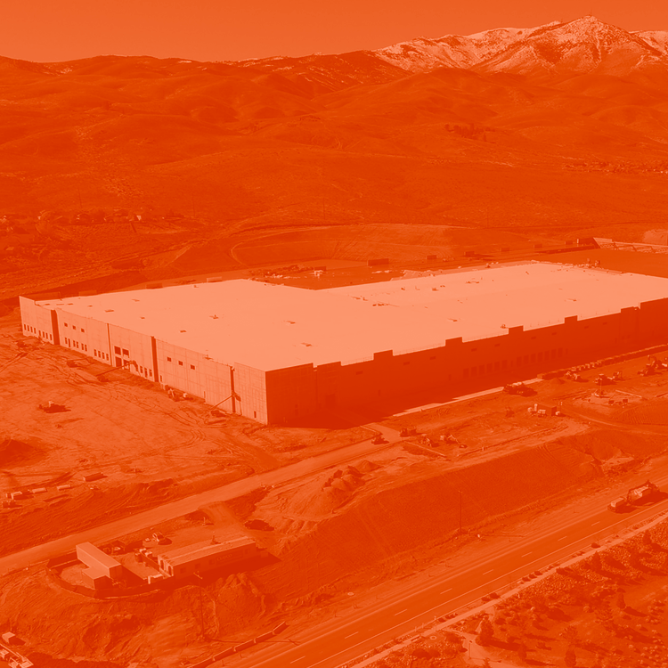 Aerial view of a building being constructed. The image is edited with an orange duotone look.